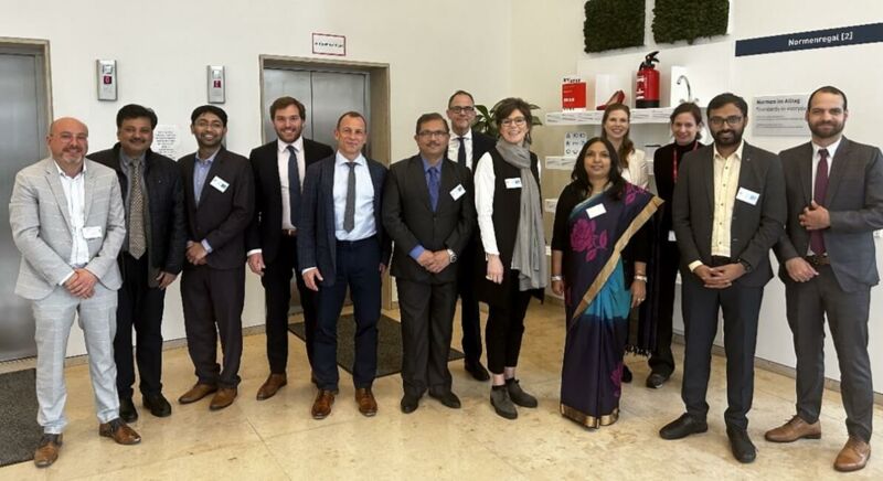 People pose together in front of a lift for a group photo.